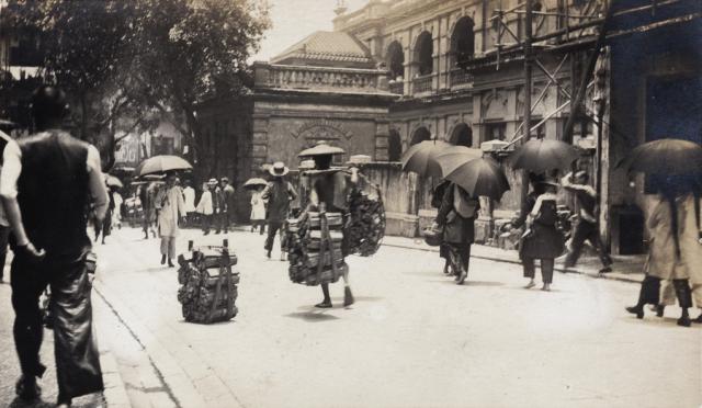 Porters carrying wood, outside Belilios Public School, Hollywood Road