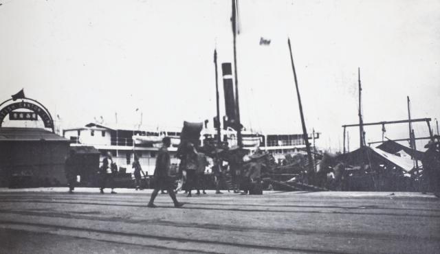 A pier with a British Canton Line sign, and a steamer, early 1920s