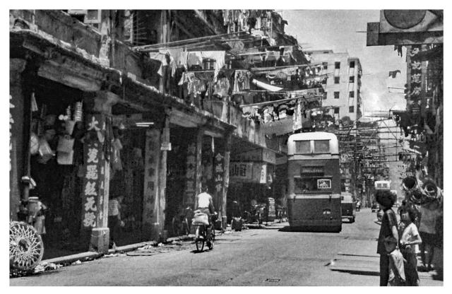 Kowloon domestic washing drying poles hanging over the busy street-1960s