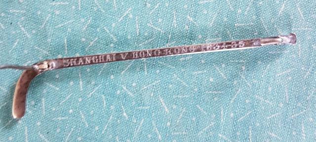 Hockey stick brooch engraved 'Shanghai v Hong Kong 1934-35'