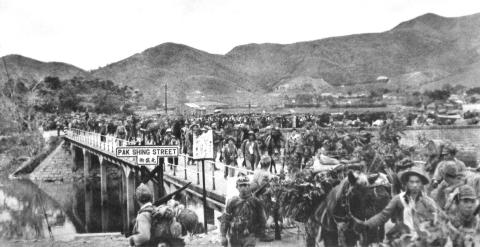 Japanese Soldiers of the 228 Battalion, 38 Regiment cross the Kwong Fuk Bridge.