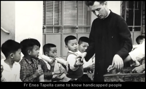 Father Enea Tapella hands out food to children