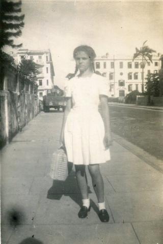 1948 Corrine in KGV School uniform outside her home in Kowloon
