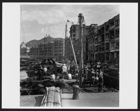 Dock workers waiting for cargo from cargo junks, Central District, Hong Kong Island.
