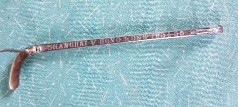 Hockey stick brooch engraved 'Shanghai v Hong Kong 1934-35'