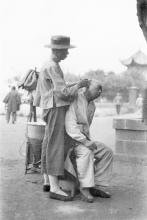 1920s Street barber cleaning customer's ears in China