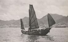 junk under sail in the harbour hong kong island in the backgroung 1954