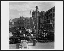 Dock workers waiting for cargo from cargo junks, Central District, Hong Kong Island.