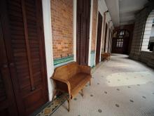 Vintage wicker chairs positioned along the wall - Kom Tong Hall