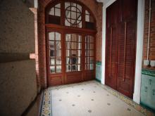 Multi-paned mirrored door at the end of hallway - Kom Tong Hall