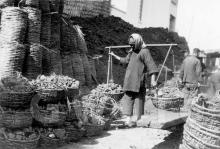 Woman carrying baskets of coal