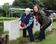 X. Rosemary places poppies at her uncle's grave.jpg